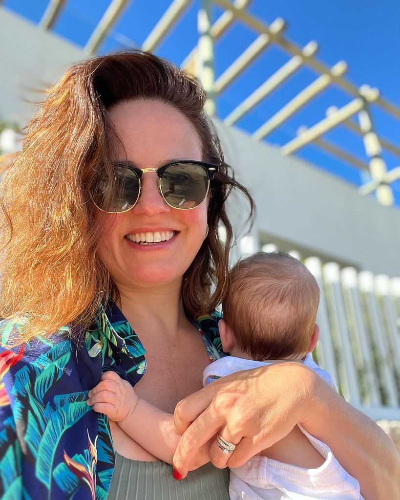 nina warhurst on holiday holding baby 