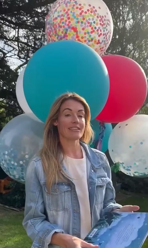 Cat Deeley in denim jacket with balloons behind her
