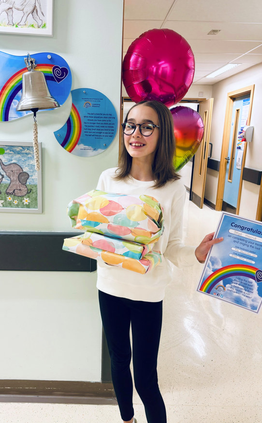 Skye in hospital holding certificates and presents