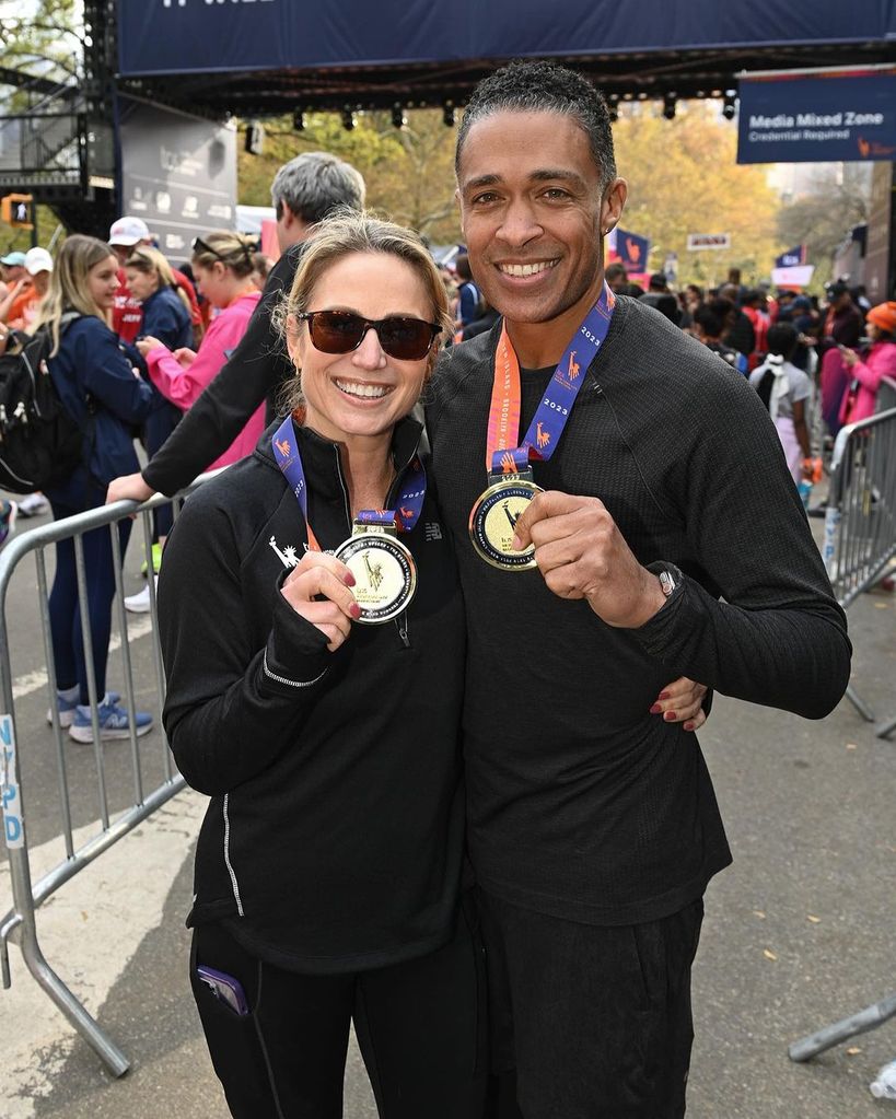 Amy Robach and T.J. Holmes holding medals after completing the New York Marathon