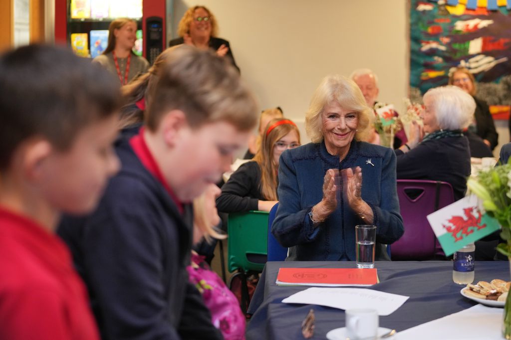 Queen Camilla applauds after listening to students as she visits Cyfarthfa Primary School to join pupils taking part in a guided reading programme 
