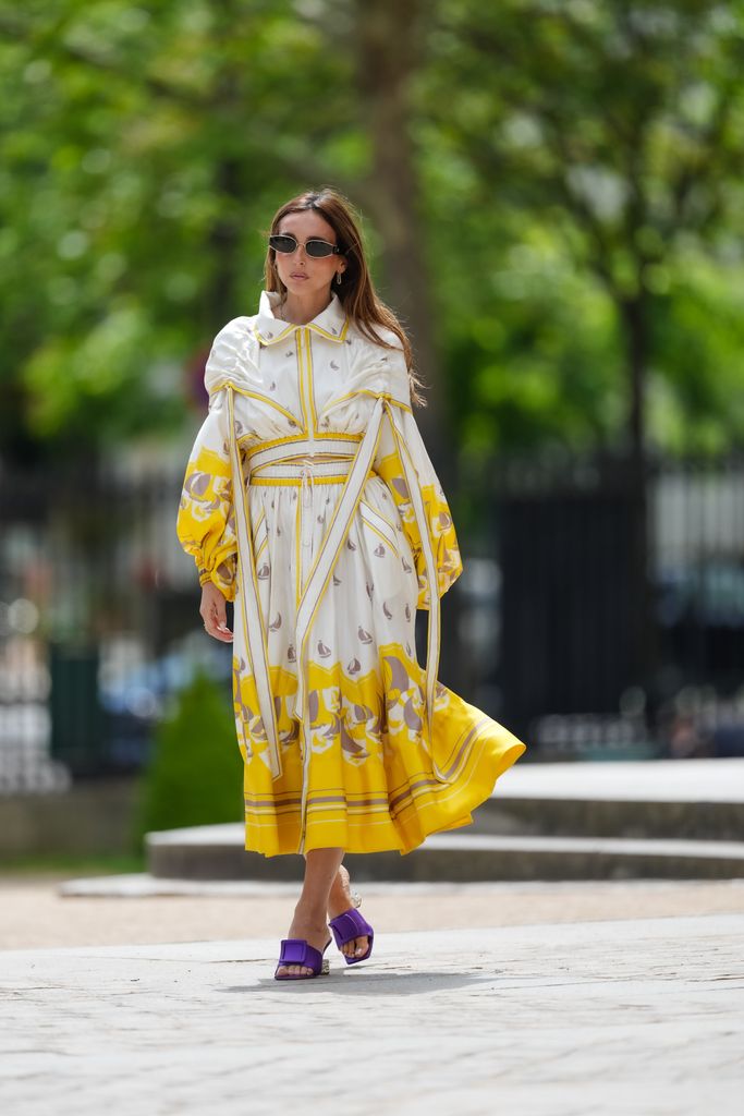 Gabriella Berdugo wears a full Zimmermann yellow and white look topped off with purple heels in Paris