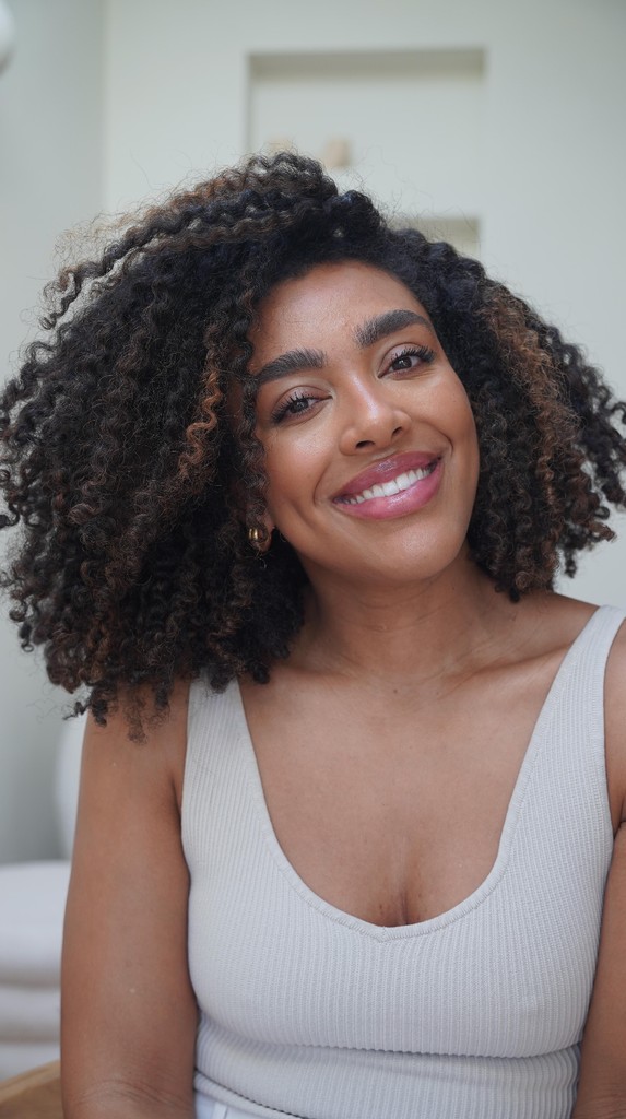 Beautiful woman smiling with curly hair in a tank top