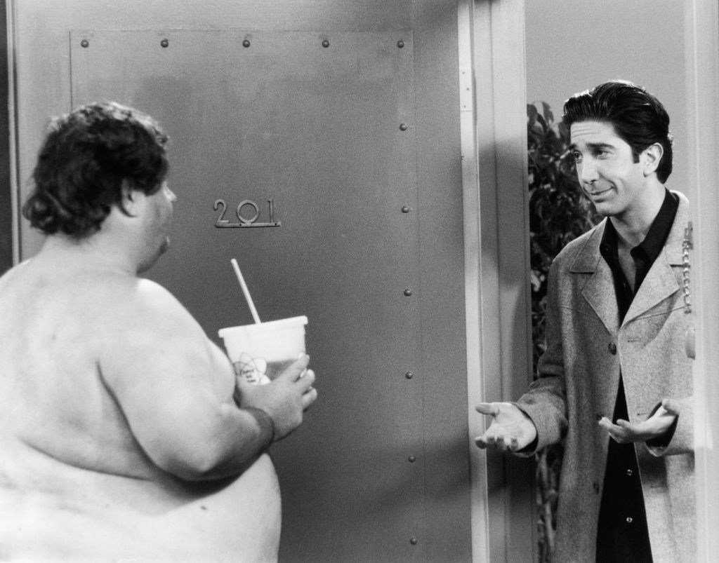 FRIENDS -- "The One Where Everybody Finds Out" Episode 14 -- Air Date 02/11/1999 -- Pictured: (l-r) Unknown as Ugly Naked Guy, David Schwimmer as Dr. Ross Geller  (Photo by NBCU Photo Bank/NBCUniversal via Getty Images via Getty Images)