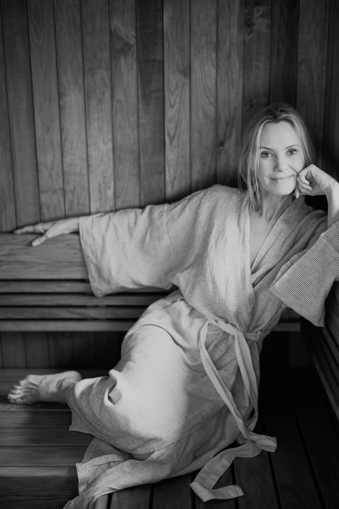 Woman smiling in a robe in the sauna