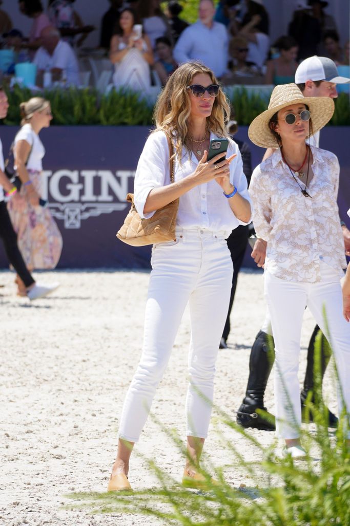 Gisele Bundchen on beach in white jeans