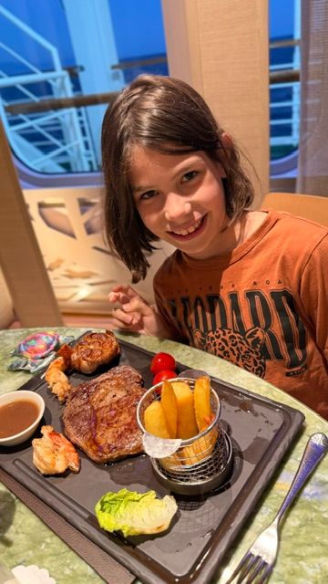 Girl eating steak at The Glasshouse restaurant on P&O cruise ship Azura