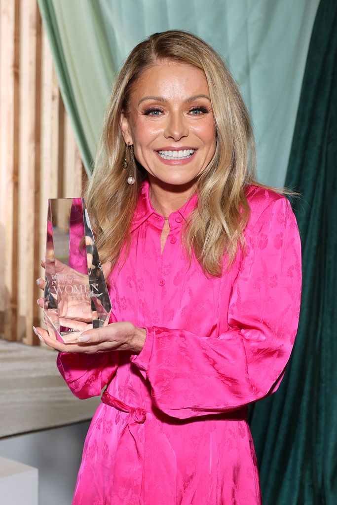 Kelly Ripa holding her award, given to her by Variety