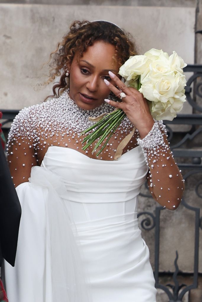 Mel in bridal gown holding flowers