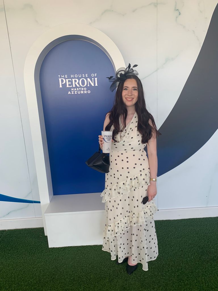 katie daly in polka dot dress holding cup