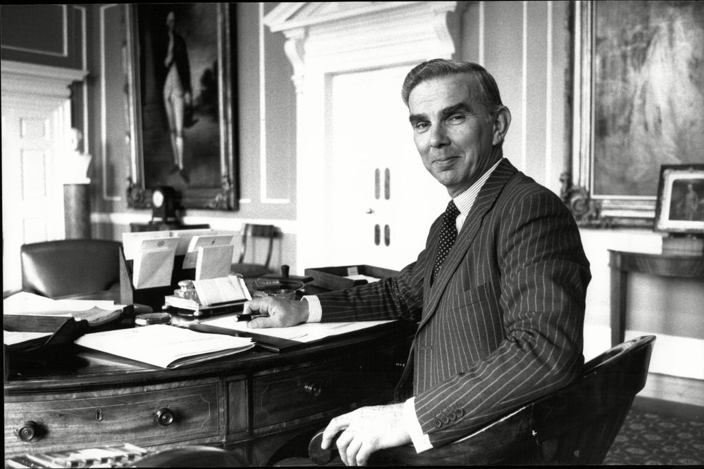 black and white photo man sitting at desk