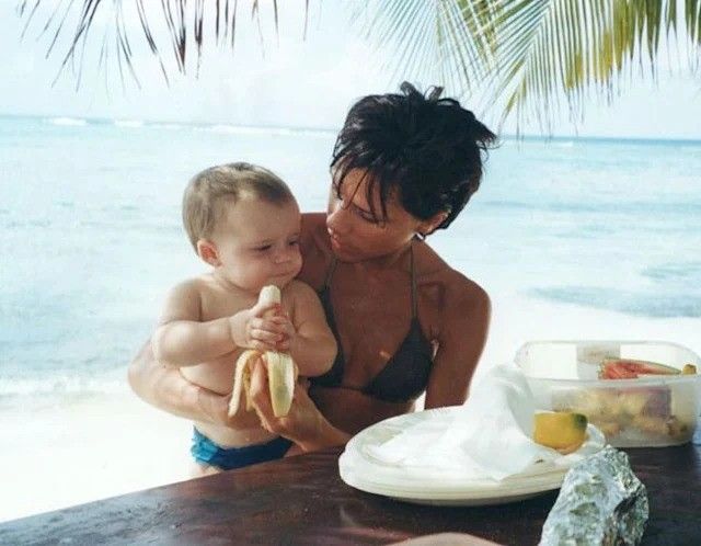 victoria and brooklyn beckham with brooklyn eating a banana