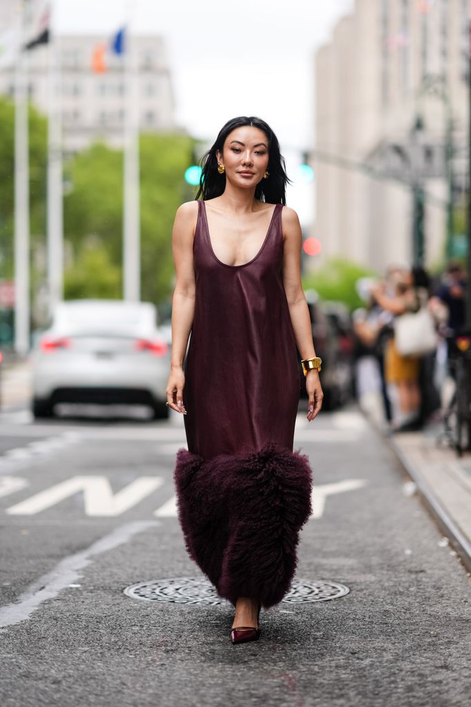 Jessica Wang wears dark brown midi dress with fluffy detail, gold bracelets, shiny dark brown pointed toe heels, outside Prabal Gurung, during the New York Fashion week Spring/Summer 2025 on September 07, 2024 in New York, New York. 