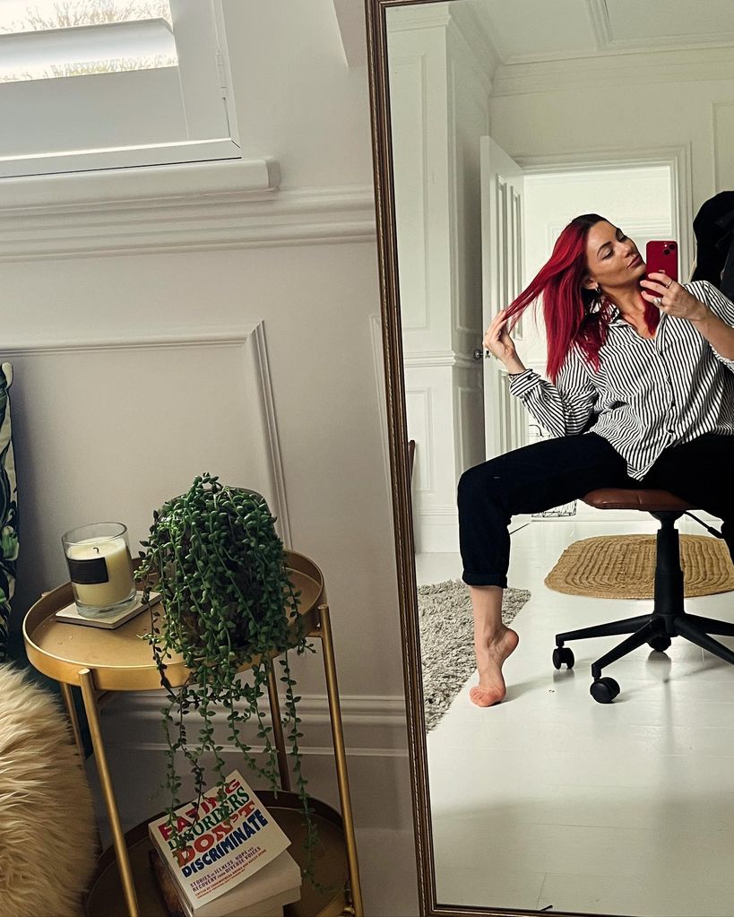 Dianne Buswell is seated on an office chair in her bedroom