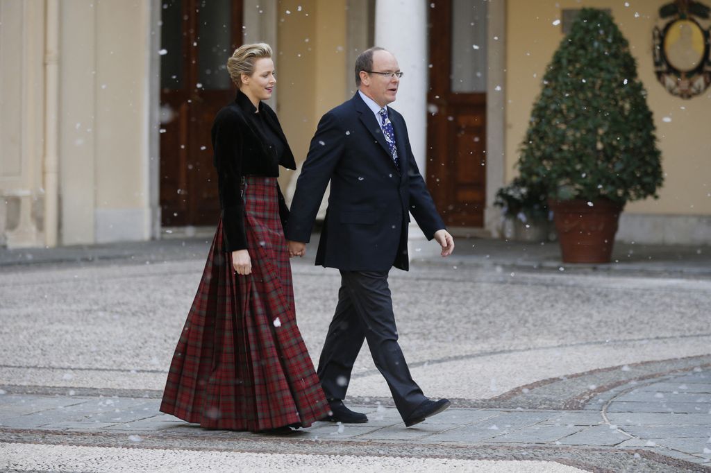 Prince Albert II of Monaco and his wife Charlene arrive to take part in a Children's Christmas ceremony on December 18, 2013 at the Monaco Palace in festive looks