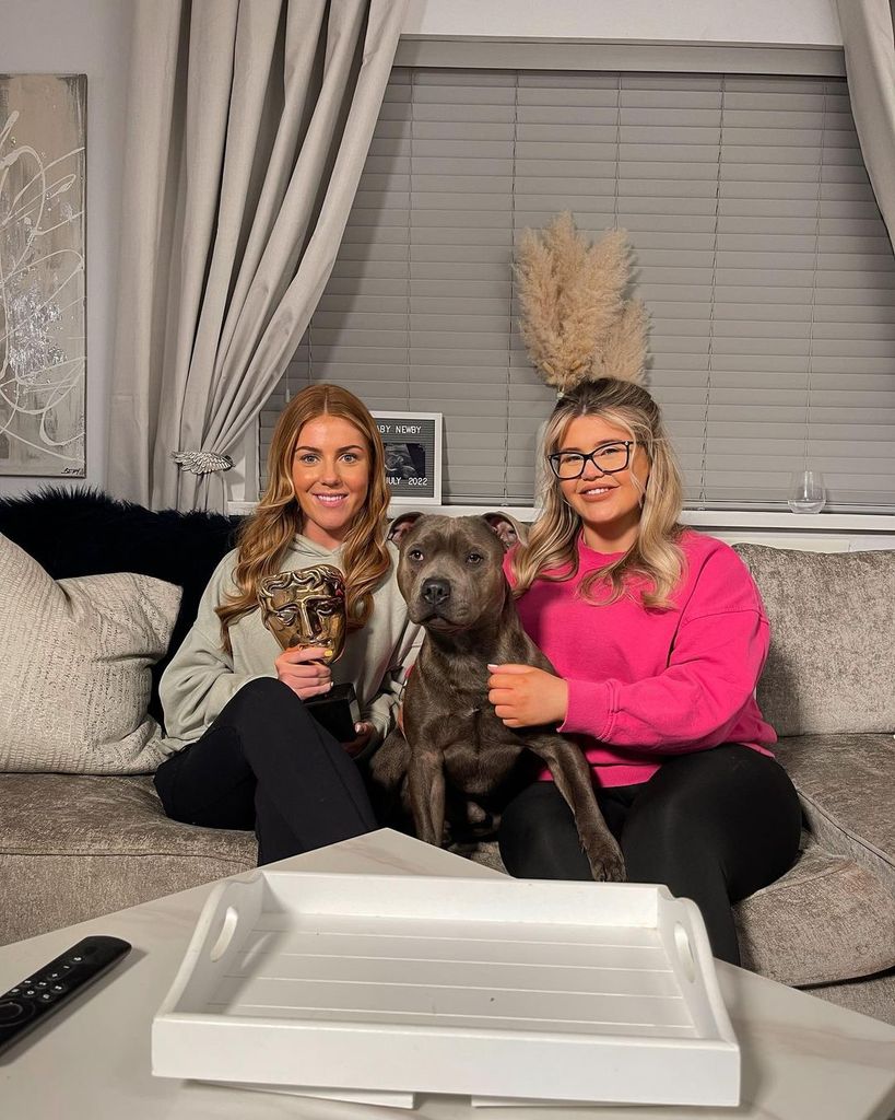 Georgia Bell and Abbie sitting on the sofa with their dog