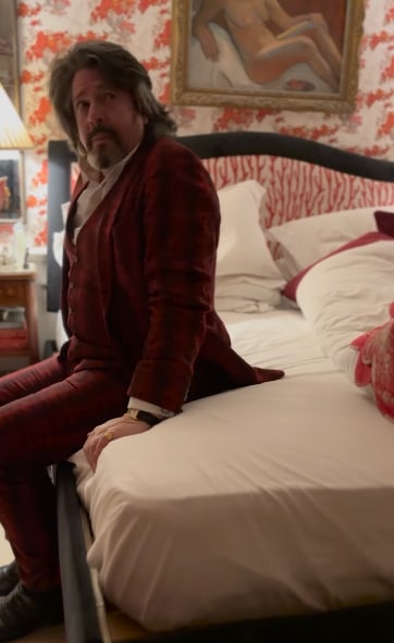 man on bed in orange bedroom