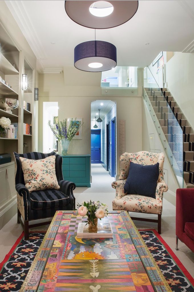 9 astuces simples pour élever votre petit salon selon un architecte d'intérieur 9 salon avec escaliers à droite avec chaises et tapis imprimés