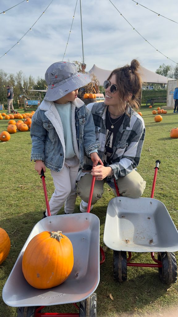 woman and son picking pumpkins