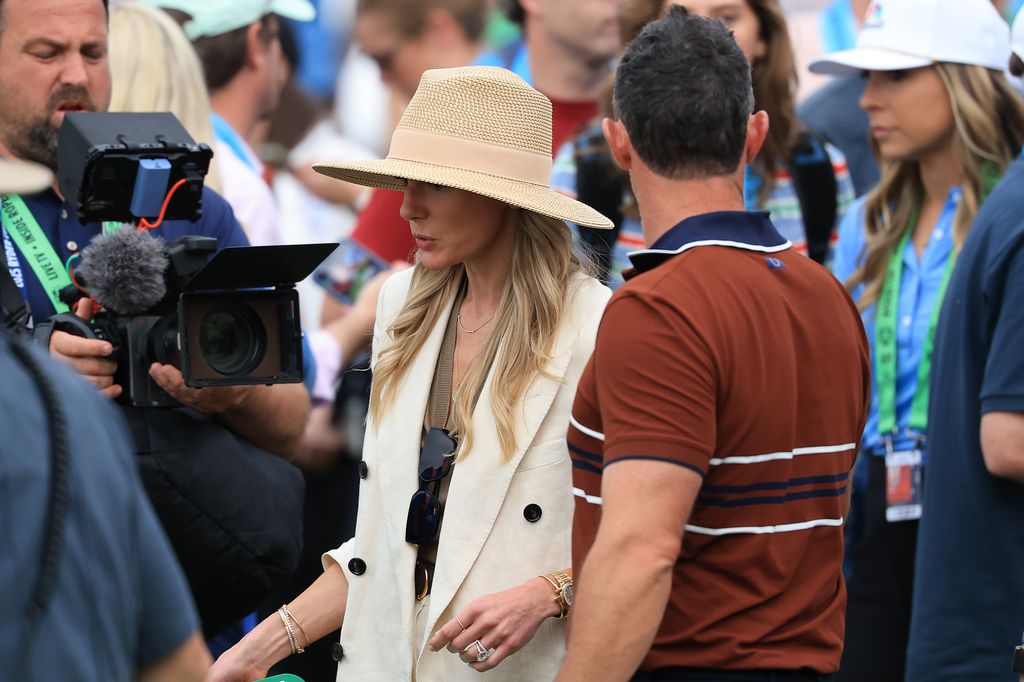 Rory McIlroy of Europe walks off with his wife Erica after winning his match during the Saturday afternoon four-balls matches of the 2025 Ryder Cup at Black Course at Bethpage State Park Golf Course on September 27, 2025 in Farmingdale, New York