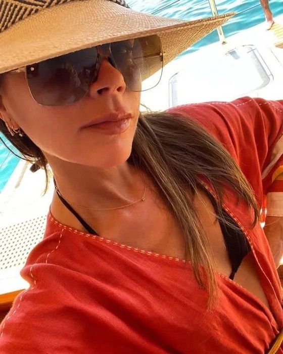 victoria beckham in a kaftan on a boat