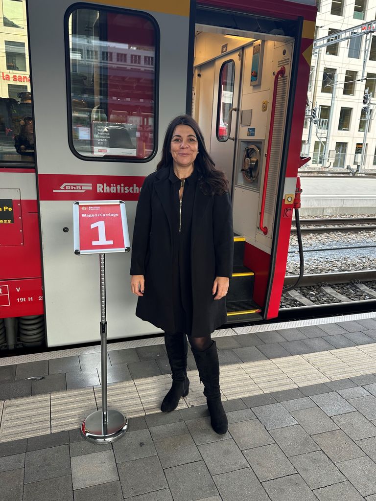 woman in black standing beside a train 