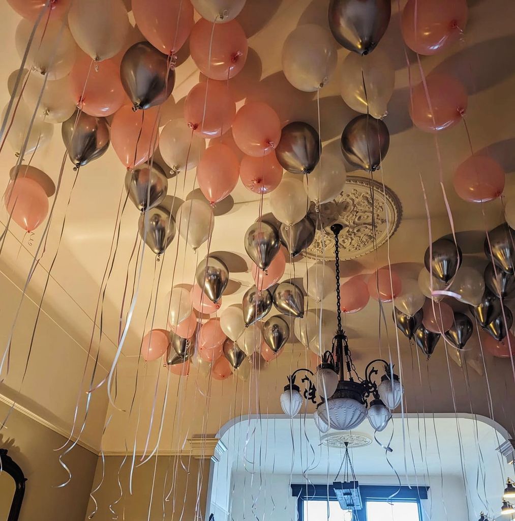A photo of pink, metallic grey and pearl-white balloons