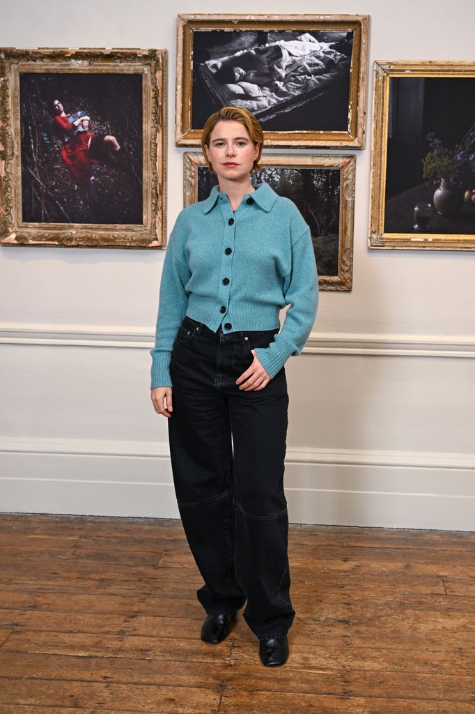 Jessie Buckley posed in blue jumper and black jeans at gallery 