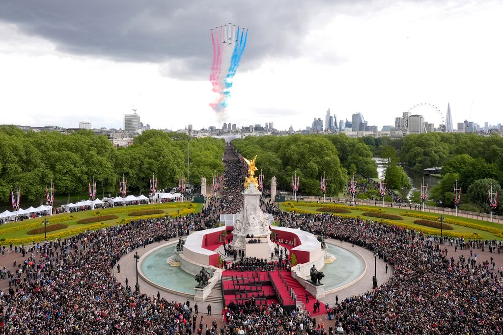 The Red Arrows fly over the crowds gathered outside Buckingham Palace in central London