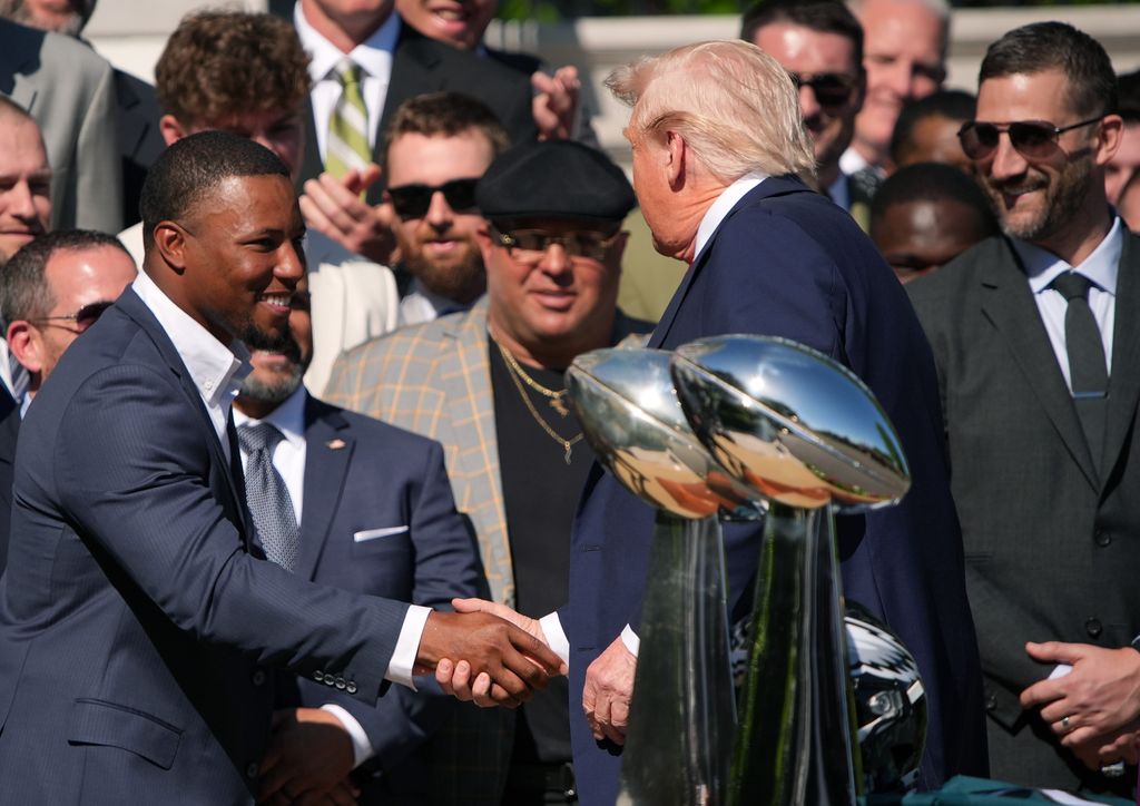 U.S. President Donald Trump (C) greets Philadelphia Eagles running back Saquon Barkley alongside head coach Nick Sirianni at an event welcoming the 2025 Super Bowl Champion Philadelphia Eagles on the South Lawn of the White House on April 28, 2025 in Washington, DC. President Trump honored the Eagles after their second Super Bowl victory, following their first win in 2018