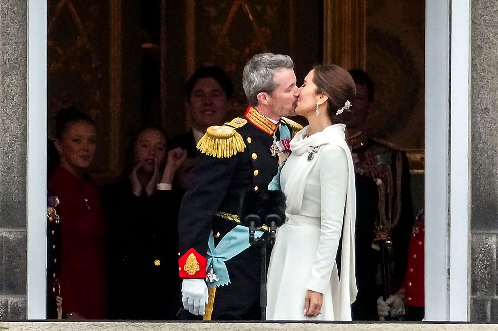 King Frederik and Queen Mary's children look on as their parents kiss