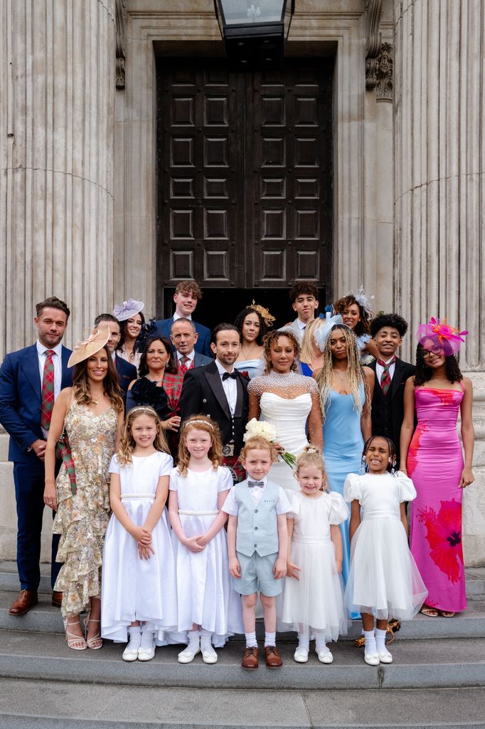 Mel B and Rory McPhee posing outside St Paul's Cathedral alongside their flower girls and children 