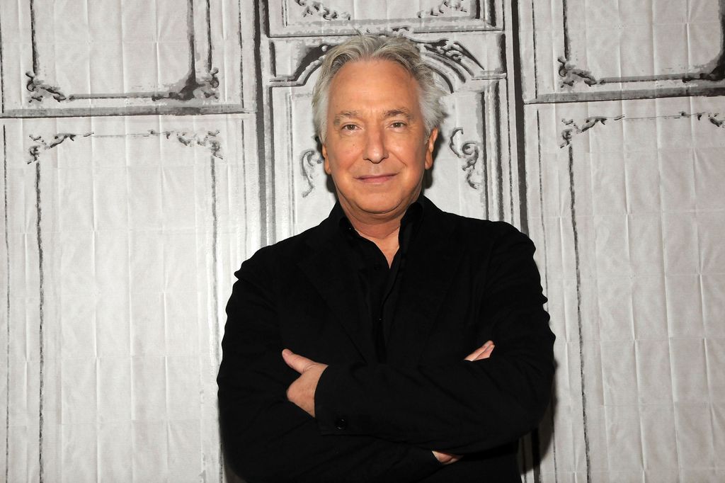 Alan Rickman in a black outfit with his arms crossed