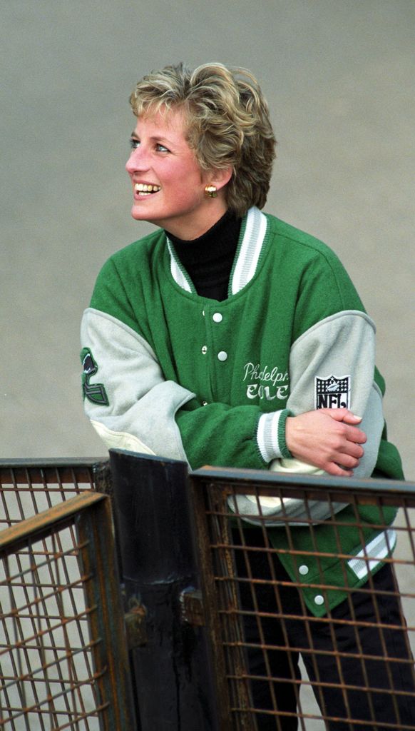 With her arms folded, Princess Diana beams while rocking the green-and-gray varsity jacket. The relaxed yet polished styling proves why she remains an enduring fashion icon.