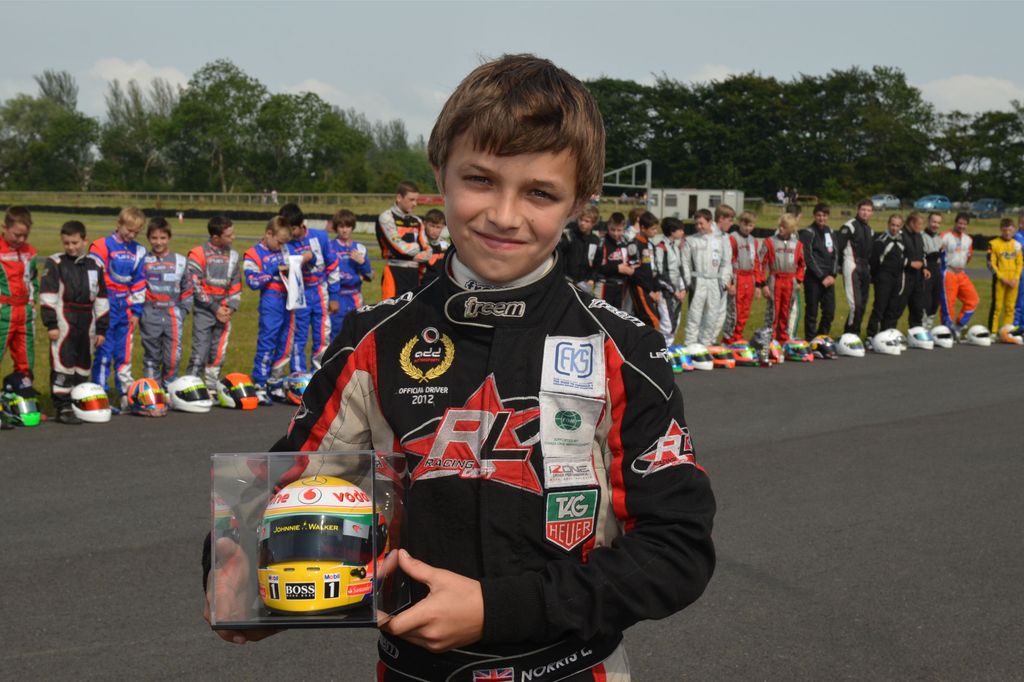 A young Lando Norris holding a trophy