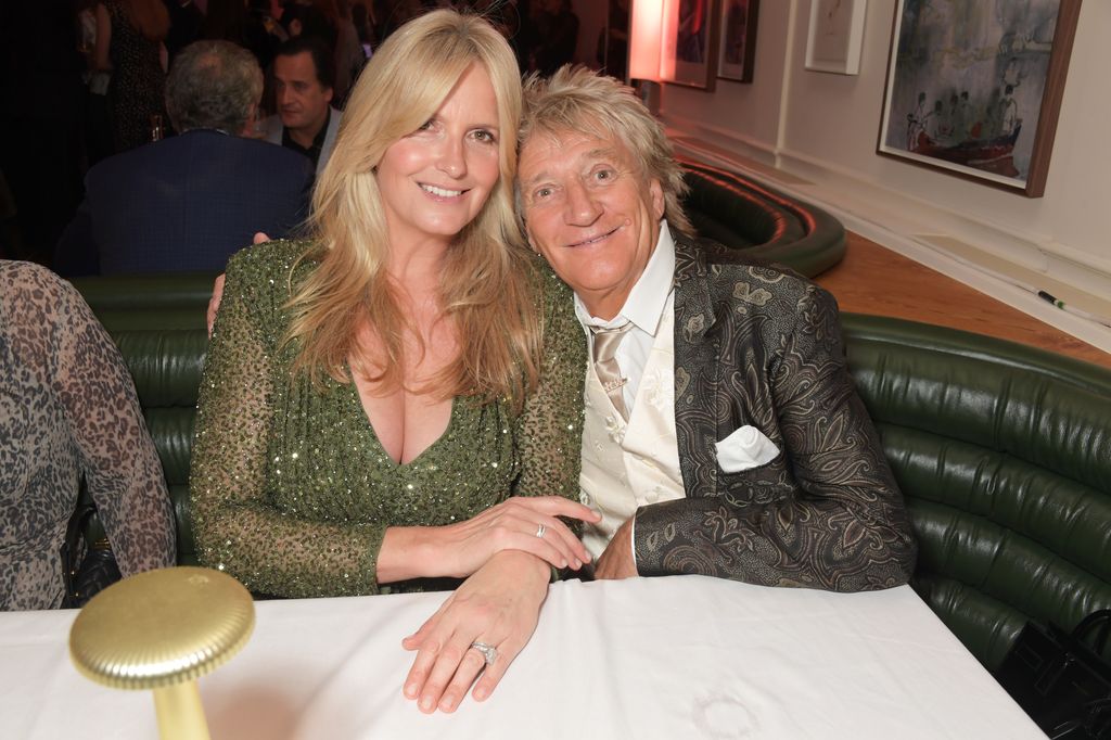 Penny Lancaster and Sir Rod Stewart sitting at table smiling