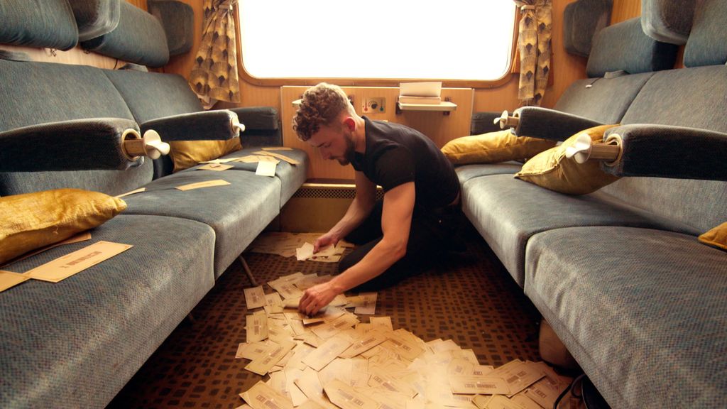 Homme assis sur sol en regardant des morceaux de papier