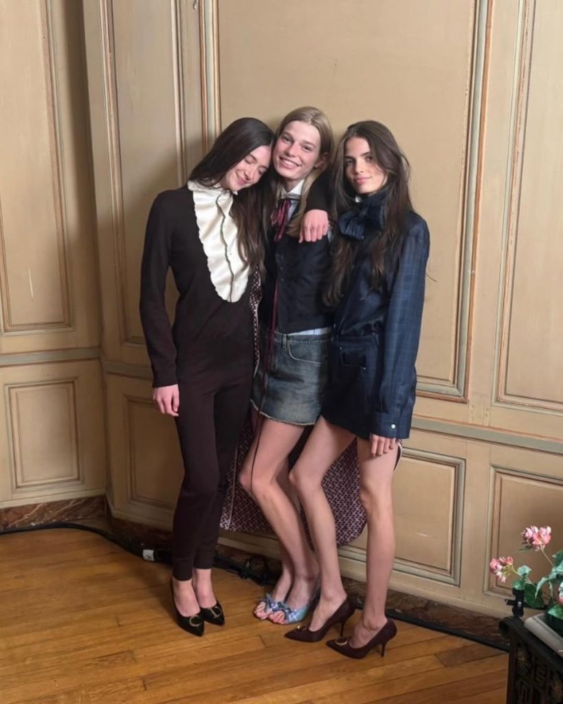 Sunday Rose in brown outfit posing with friends