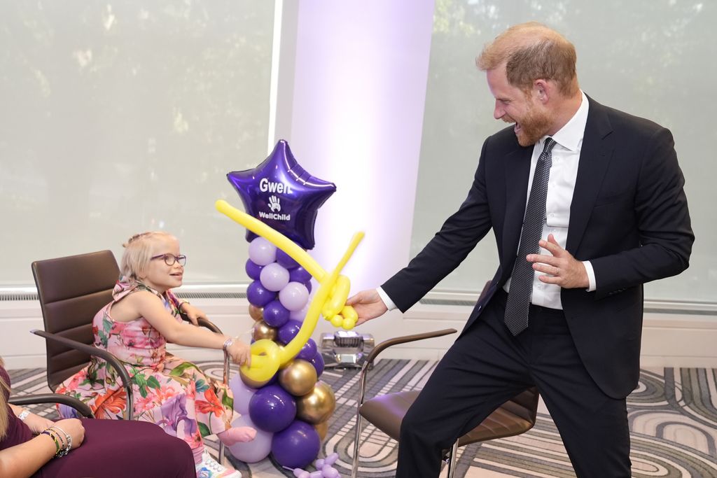 Prince Harry, Duke of Sussex play fights using swords made from modelling balloons with nine-year-old Gwen, recipient of Inspirational Child 7-11 award, at the annual WellChild Awards 2025
