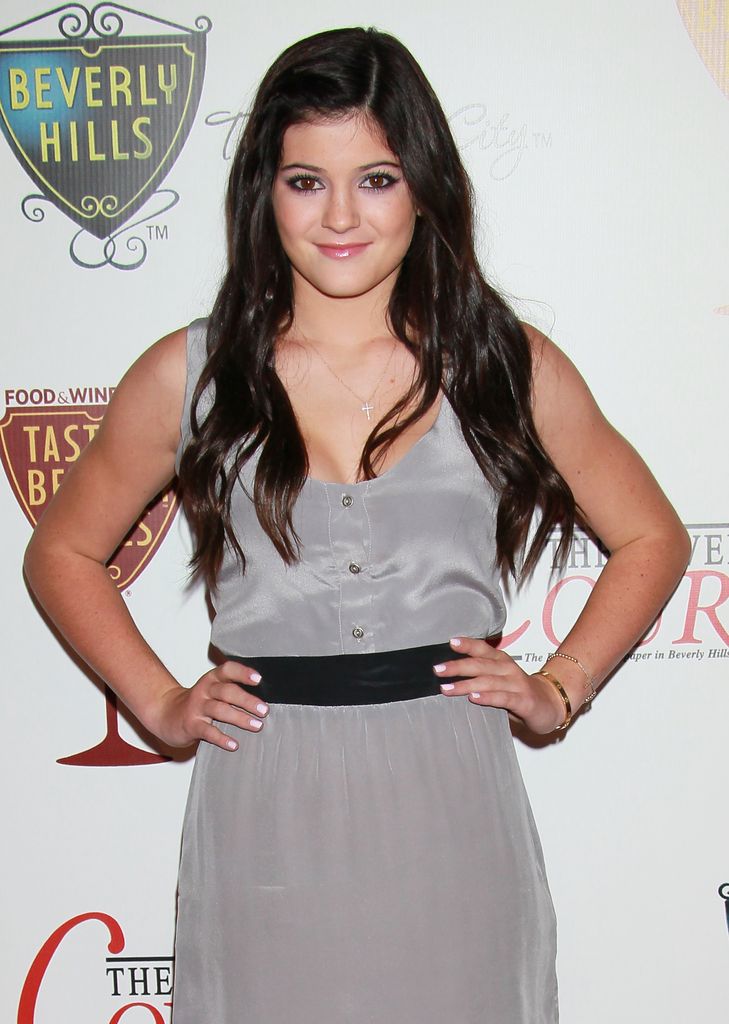 Kylie Jenner in 2010 wearing a grey dress with a black waist belt