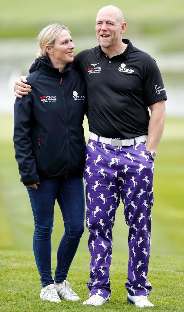 Zara Tindall in a jacket looking at Mike Tindall in a polo shirt and colourful trousers