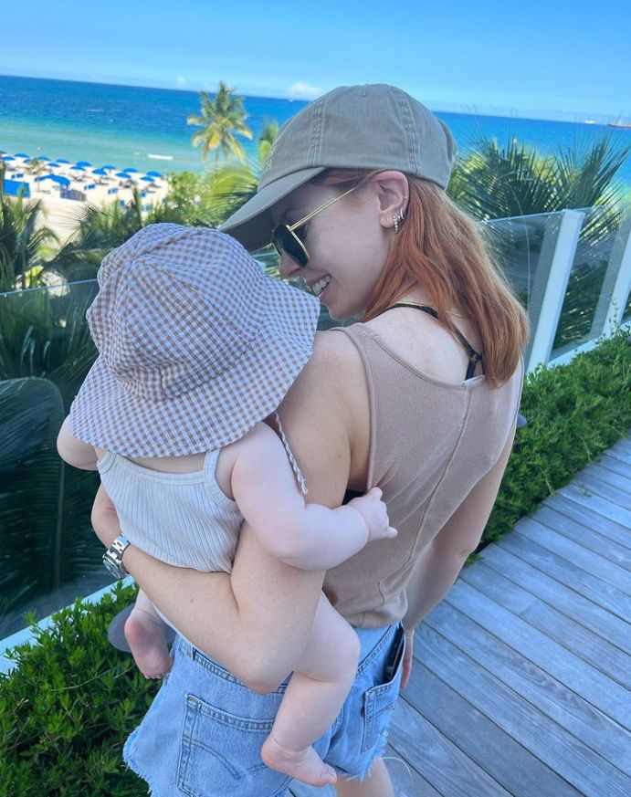 Stacey Dooley holding baby Minnie who wears a sunhat