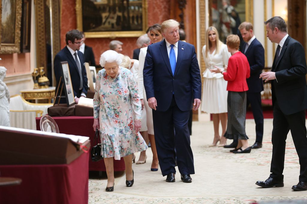 Harry in the background at Buckingham Palace as Donald Trump walks with the Queen