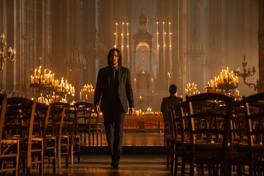 Canadian-born actor Keanu Reeves (in costume as 'John Wick') walks along an aisle in the Church of Saint-Eustache, in a scene from the film 'John Wick: Chapter 4' (directed by Chad Stahelski), Paris, France, October 2021. Set for release in 2023, the film