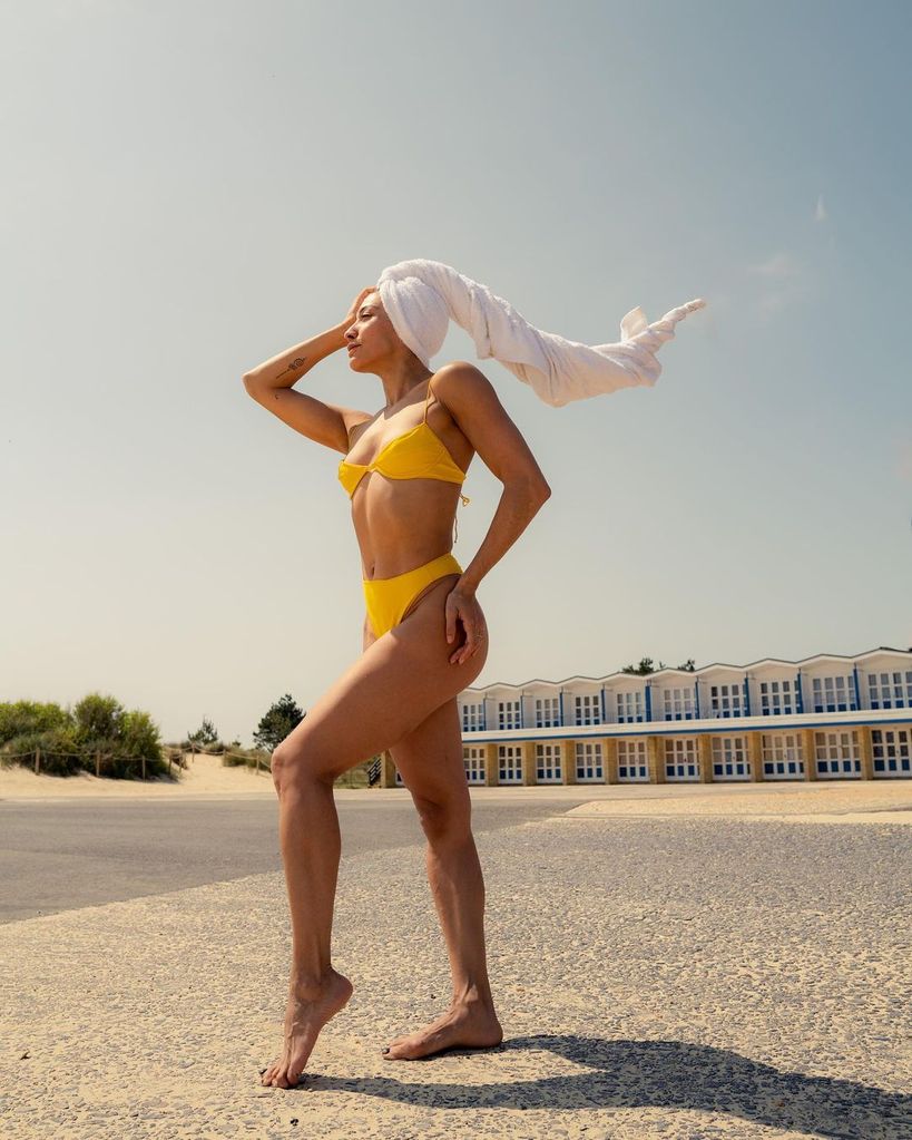 Karen Hauer posing in a mustard bikini with a towel on her head