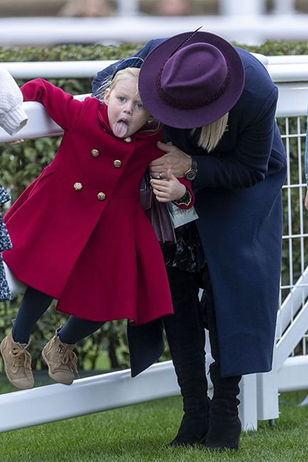 lena tindall sticking out tongue in red coat with zara tindall at cheltenham racecourse
