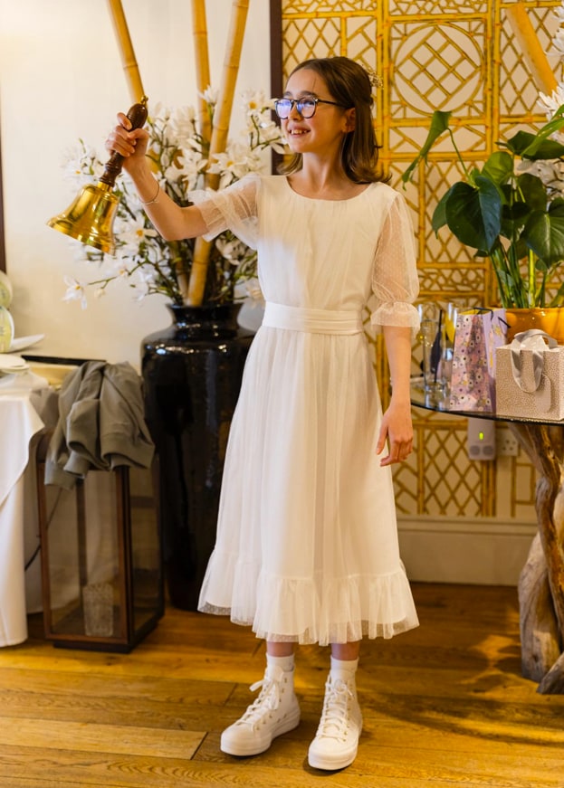 Skye in white dress ringing bell