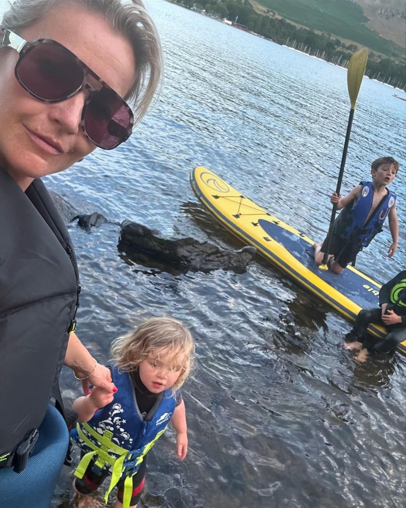 mother holding daughter's hand in lake