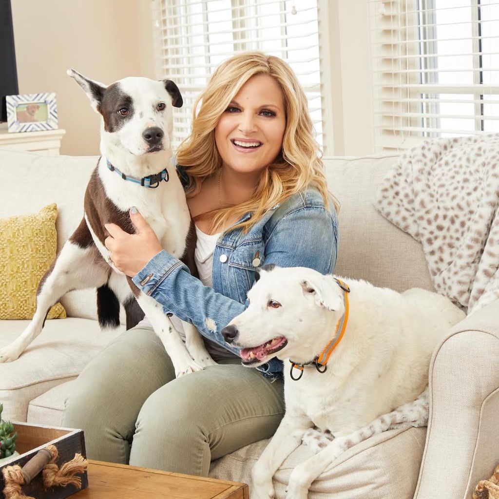 Trisha Yearwood sits on her sofa with two dogs