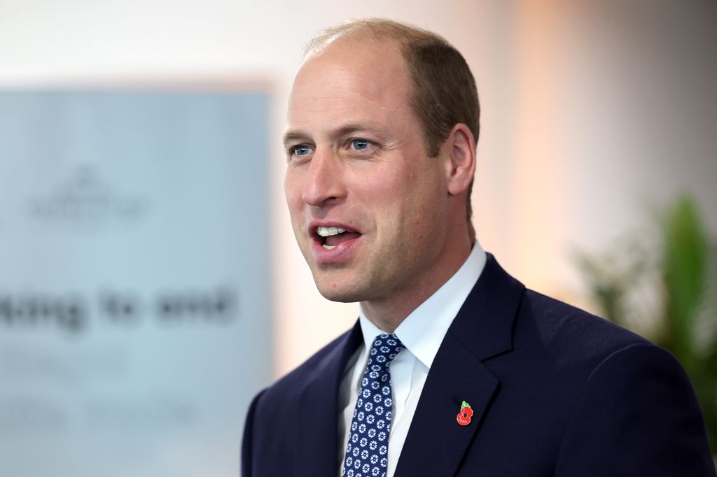 Prince William smiling in a suit and tie